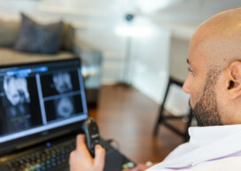 Black Male Radiologist Doctor Reading X ray Images on Laptop from Home