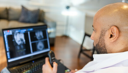 Black Male Radiologist Doctor Reading X ray Images on Laptop from Home