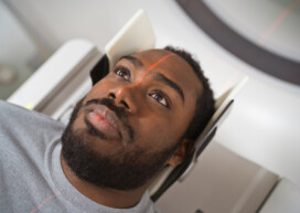 Male patient undergoing MRI scan in medical examination room